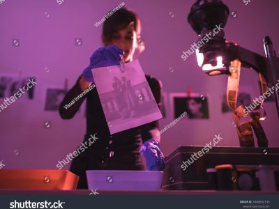 stock-photo-female-photographer-developing-film-and-printing-photographs-in-traditional-process-in-darkroom-1846692145